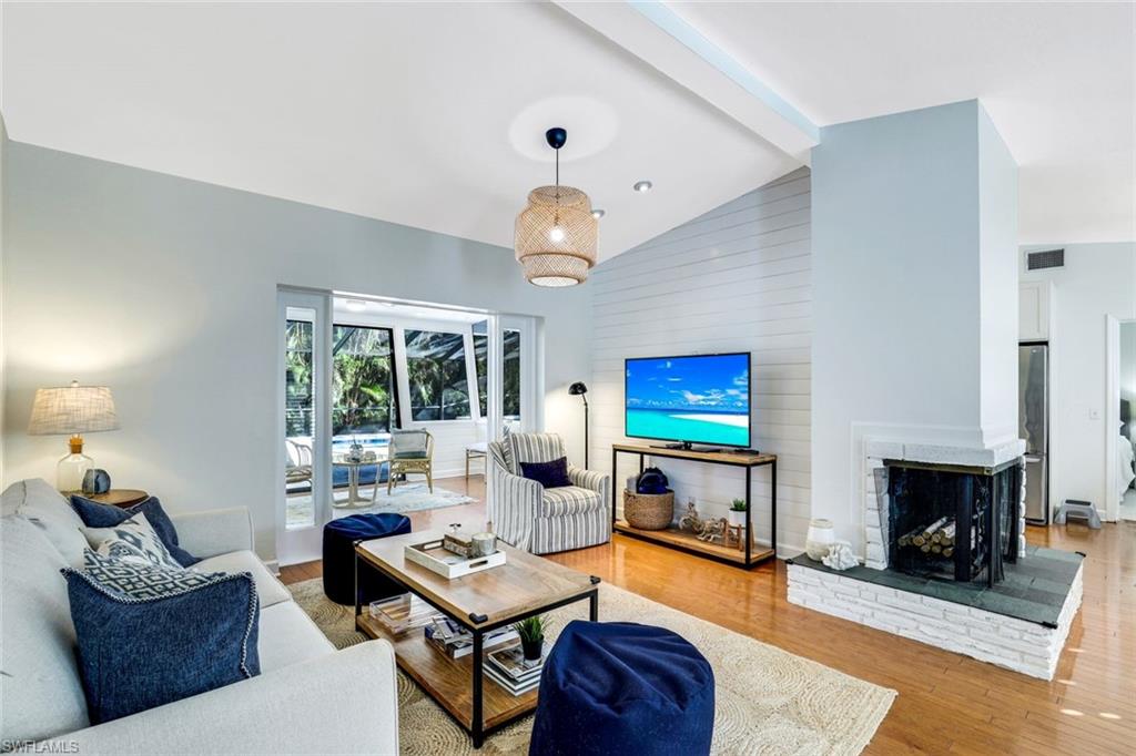 739 7th Avenue North Naples, FL 34102 - Photo 7 of 30 a living room with furniture a fireplace and a flat screen tv