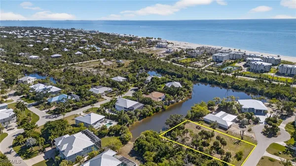 an aerial view of a city with lots of residential buildings ocean and mountain view in back