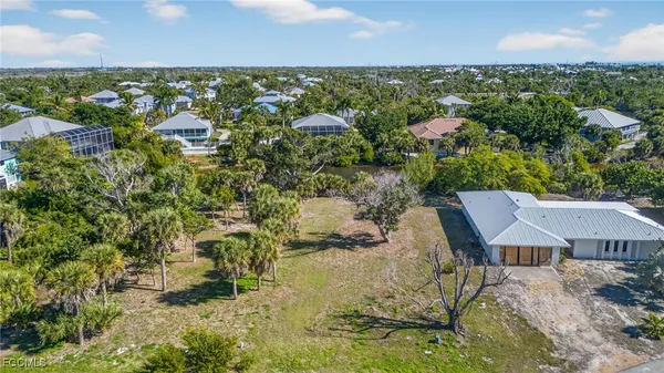 an aerial view of a house with a yard and lake view