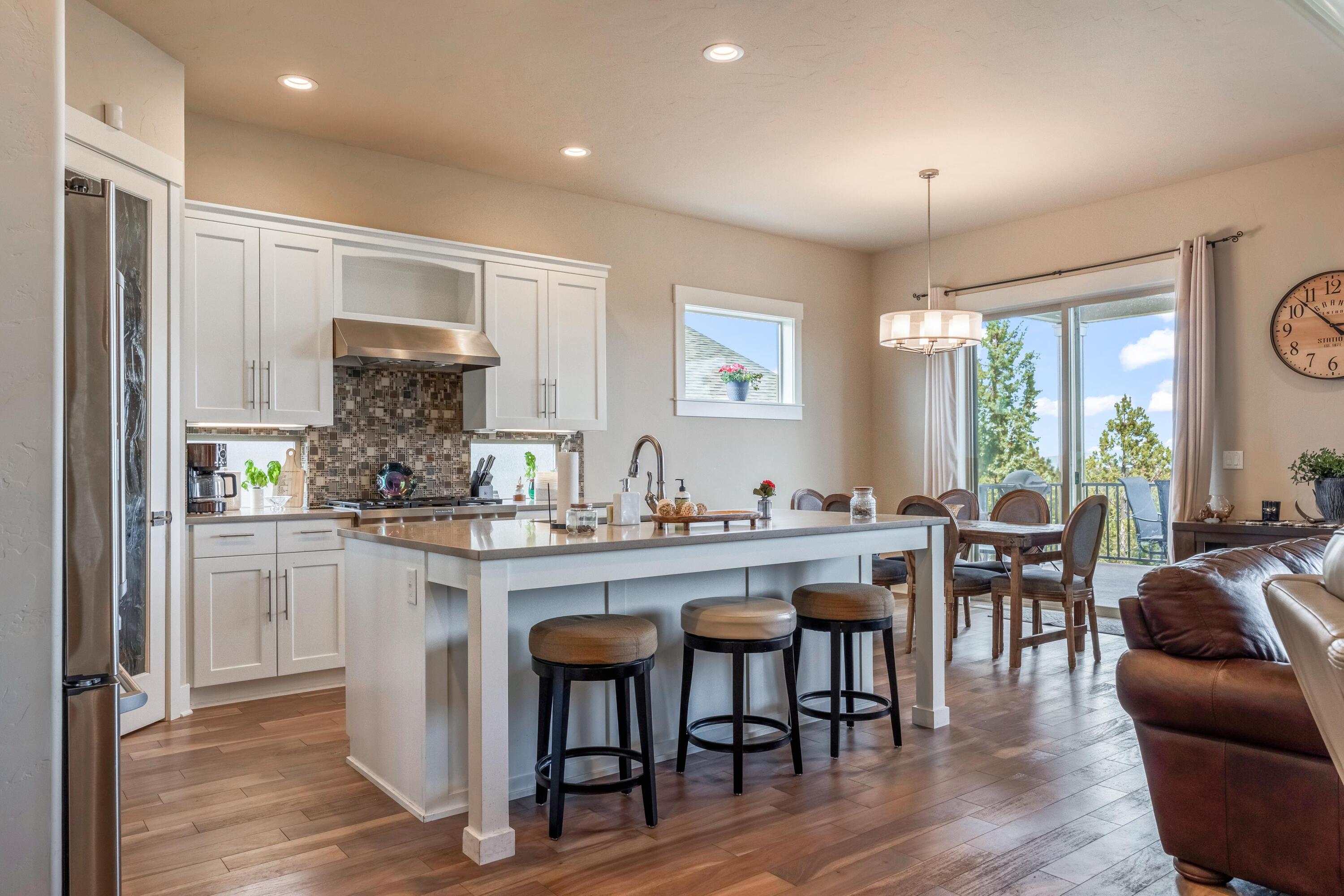 2375 Northwest Majestic Ridge Drive Bend, OR 97703 - Photo 6 of 28 a kitchen with stainless steel appliances granite countertop a table and chairs in it