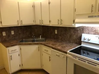 a kitchen with granite countertop white cabinets and a sink