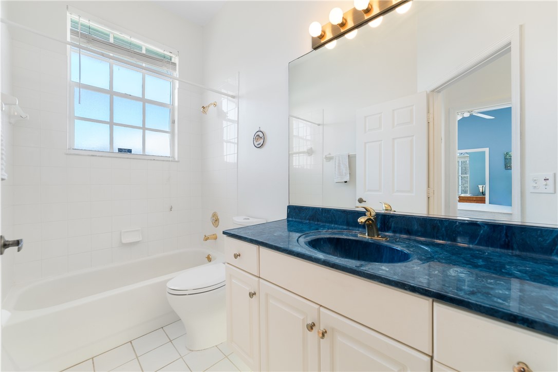 419 Ponoka Street Sebastian, FL 32958 - Photo 18 of 33 a bathroom with a granite countertop sink a toilet a mirror and bathtub
