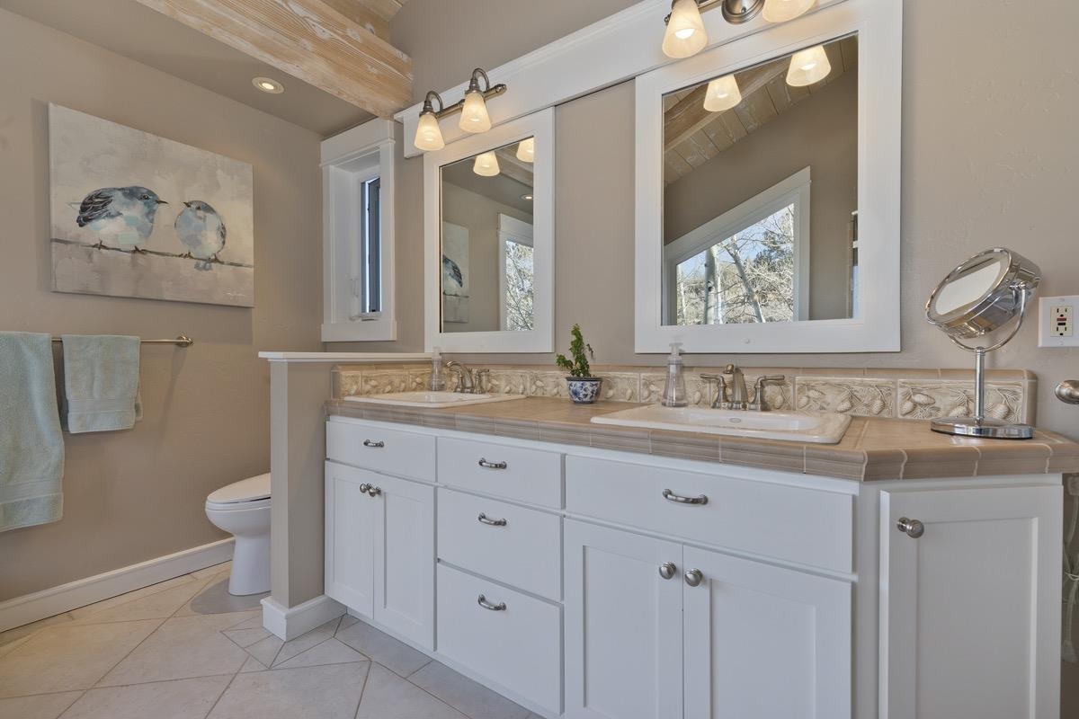96 Aspen Spring Ranch Road Mammoth Lakes, CA 93546 - Photo 16 of 43 a bathroom with a granite countertop toilet sink and mirror