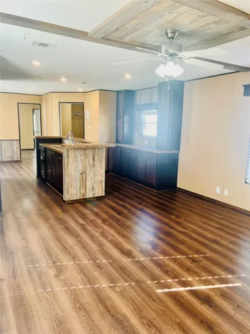 a view of a kitchen with furniture and wooden floor