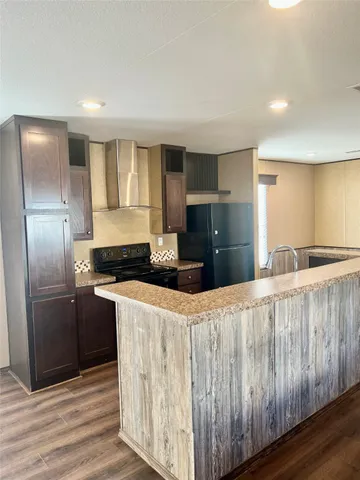 a kitchen with stainless steel appliances granite countertop a refrigerator a sink and wooden cabinets