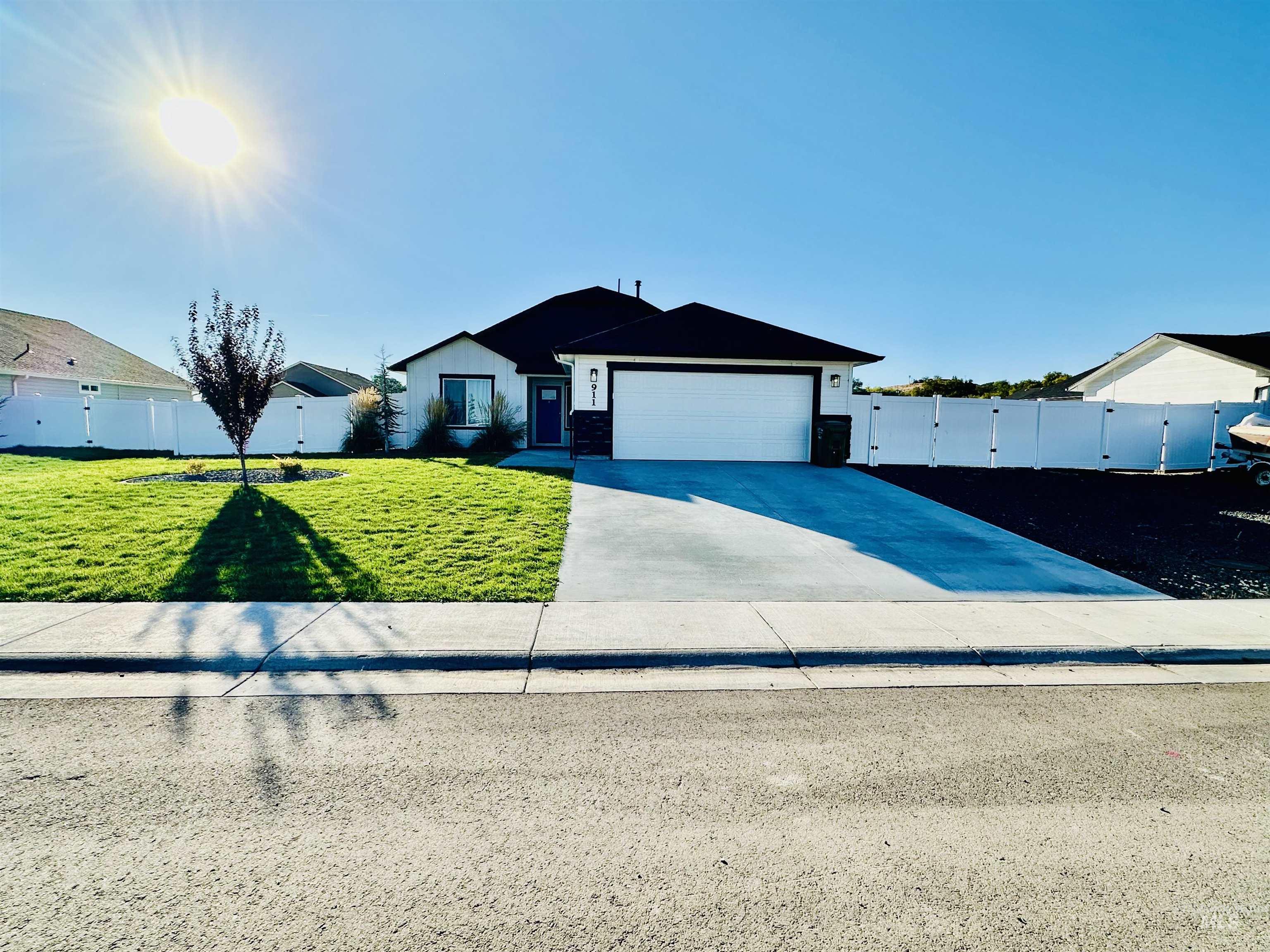 Ranch-style home with concrete driveway, a gate, and a garage