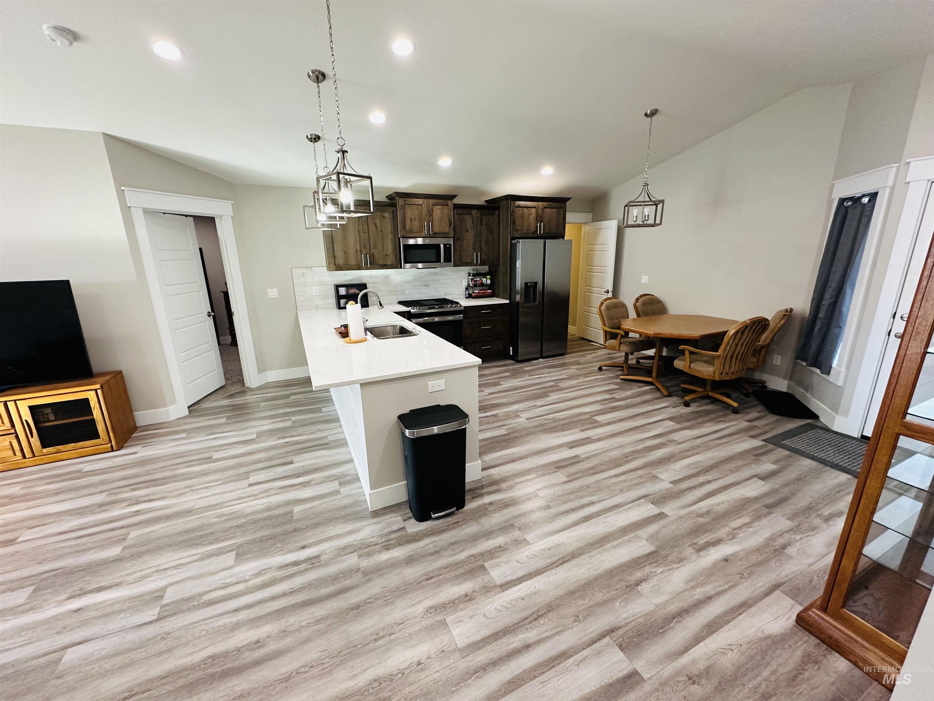 911 Campbell Street Vale, OR 97918 - Photo 6 of 37 Kitchen with dark brown cabinets, recessed lighting, backsplash, stainless steel appliances, and a peninsula
