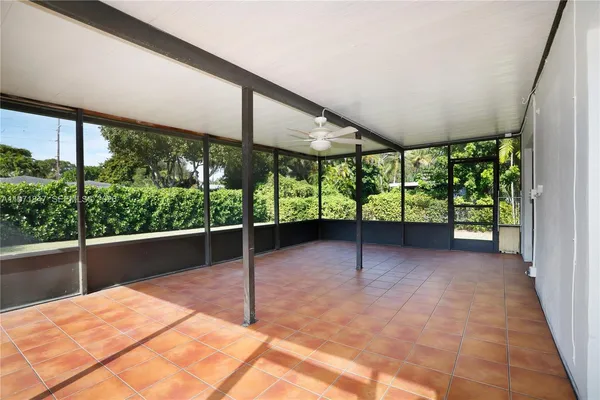a view of empty room with window and ceiling fan