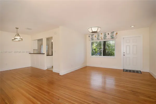 a view of empty room with wooden floor and windows