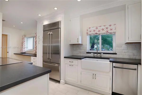 a kitchen with white cabinets and stainless steel appliances