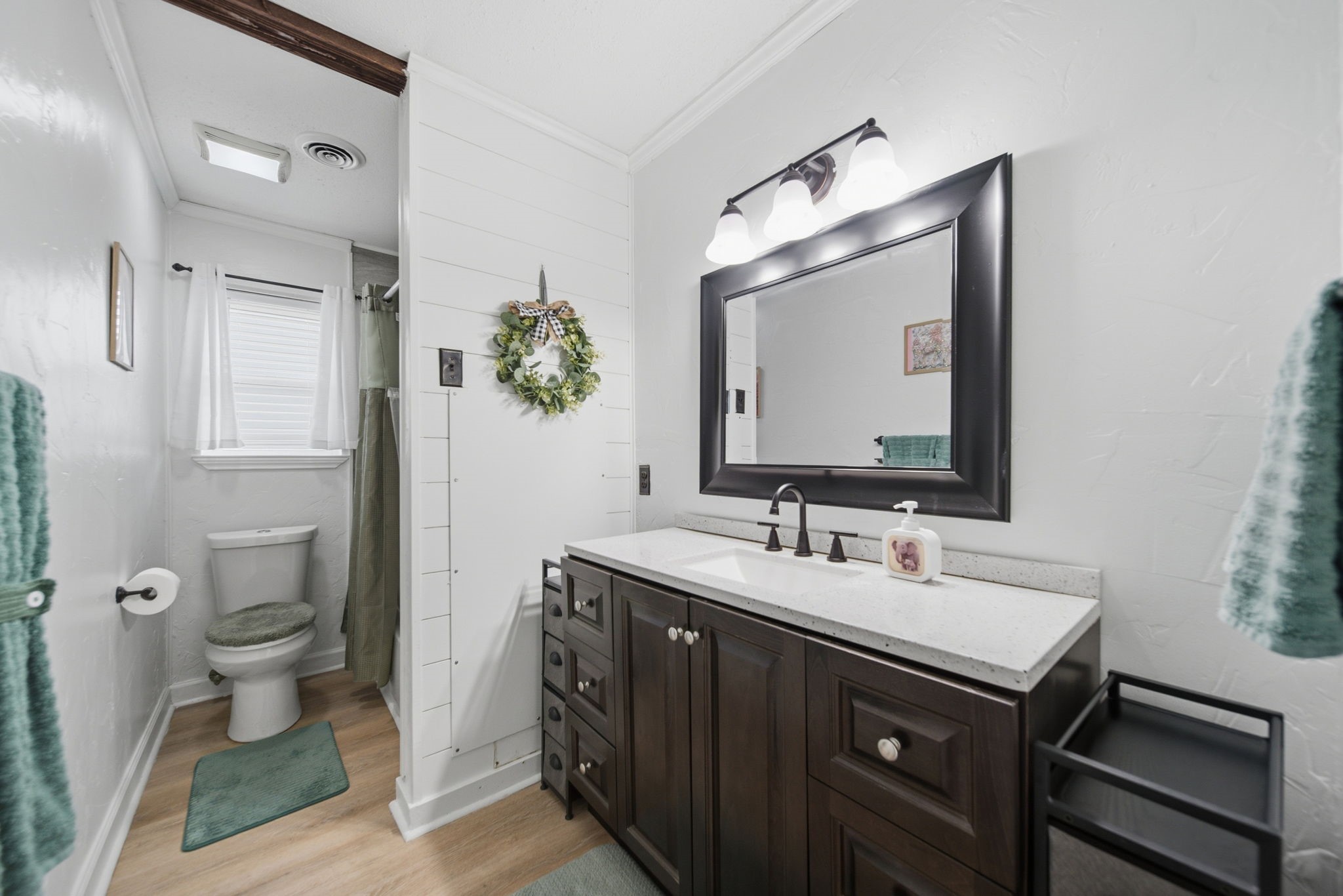 19519 Ricelake Lane Houston, TX 77084 - Photo 21 of 47 Charming bathroom featuring a sleek dark wood vanity with a modern sink, elegant lighting, and a cozy, welcoming atmosphere enhanced by light walls and warm wood flooring.