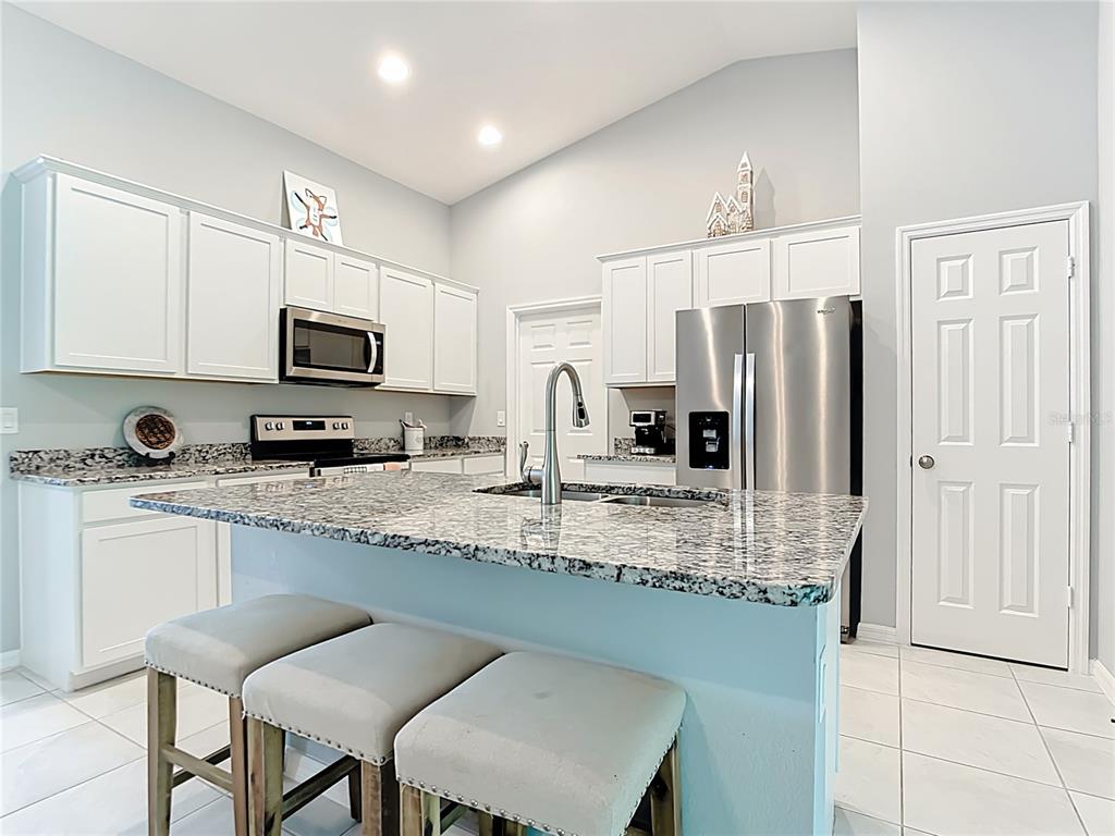 2713 Embassy Road North Port, FL 34291 - Photo 10 of 30 a kitchen with stainless steel appliances granite countertop a stove top oven a refrigerator a sink and a granite counter tops