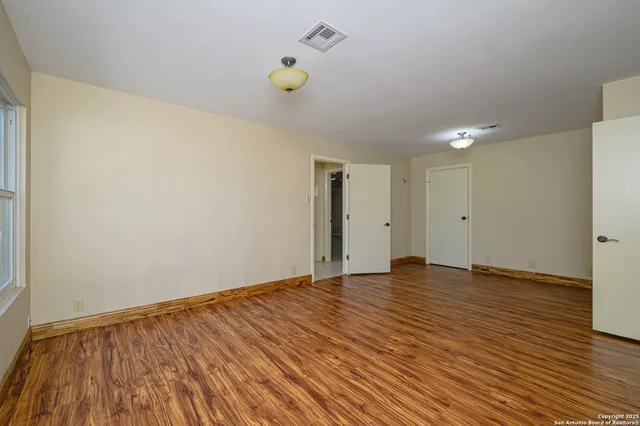 a view of an empty room and wooden floor