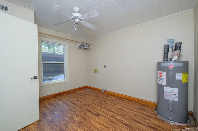 a view of empty room with wooden floor and ceiling fan