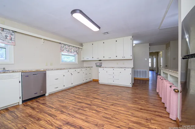 a large kitchen with cabinets and wooden floor