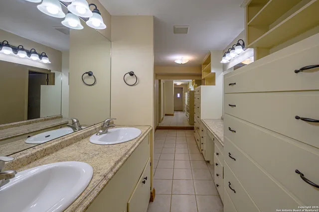 a bathroom with a granite countertop sink a large mirror and a shower