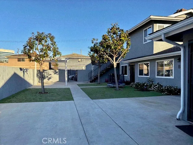 a front view of a house with a yard and potted plants