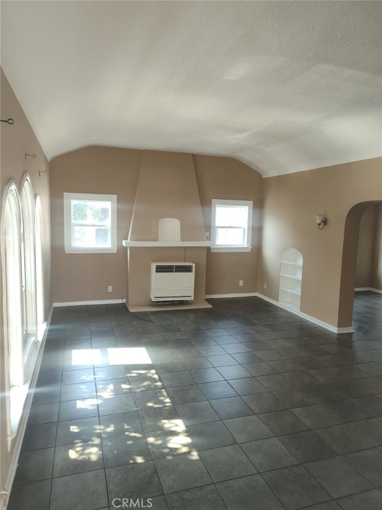 a view of empty room with window and fireplace