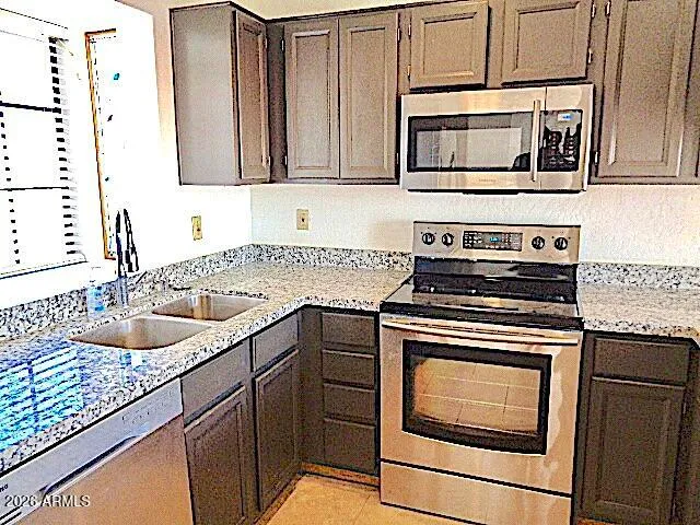 a kitchen with granite countertop cabinets stainless steel appliances and a sink