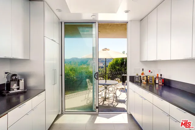 a kitchen with a large window and cabinets