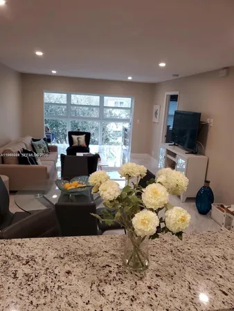 a living room with furniture large window and a flat screen tv
