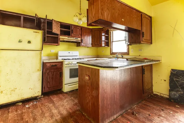 a utility room with stainless steel appliances granite countertop a sink a stove and a refrigerator