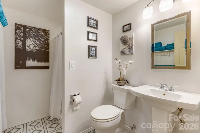 a bathroom with a toilet a sink and mirror