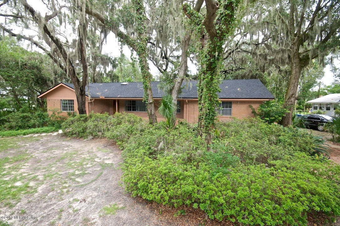 4149 Rogero Road Jacksonville, FL 32277 - Photo 1 of 27 a front view of a house with a yard and tree s