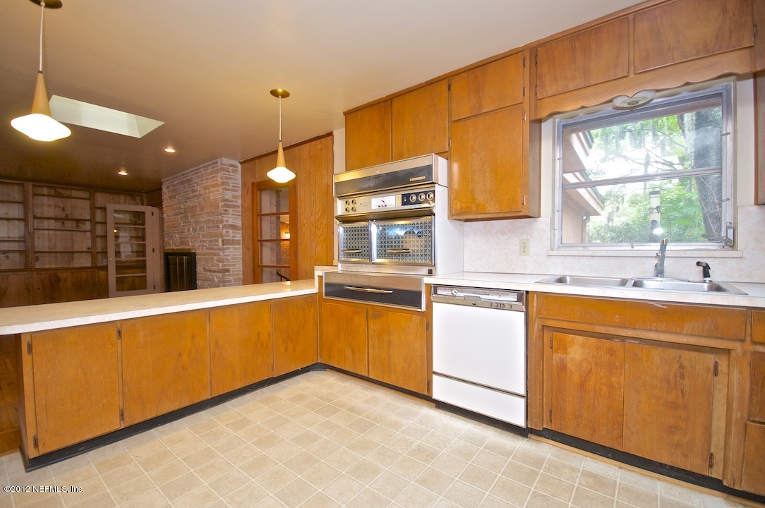 4149 Rogero Road Jacksonville, FL 32277 - Photo 11 of 27 a kitchen with stainless steel appliances granite countertop a sink and dishwasher a stove with wooden floor