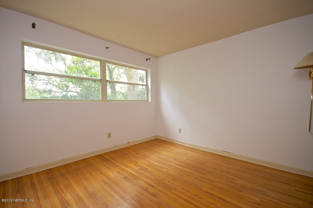 4149 Rogero Road Jacksonville, FL 32277 - Photo 17 of 27 a view of empty room with wooden floor and fan