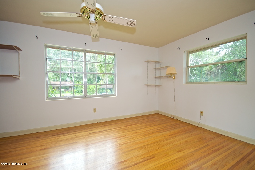 4149 Rogero Road Jacksonville, FL 32277 - Photo 18 of 27 a view of empty room with wooden floor and fan