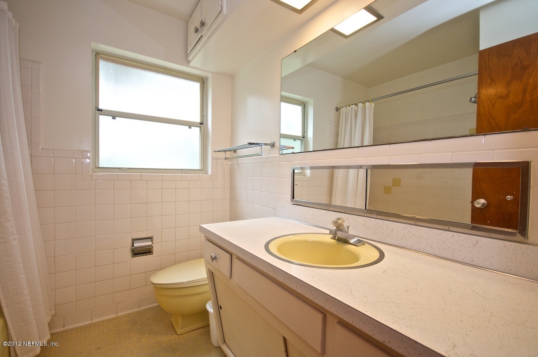 4149 Rogero Road Jacksonville, FL 32277 - Photo 19 of 27 a bathroom with a sink toilet a mirror and vanity
