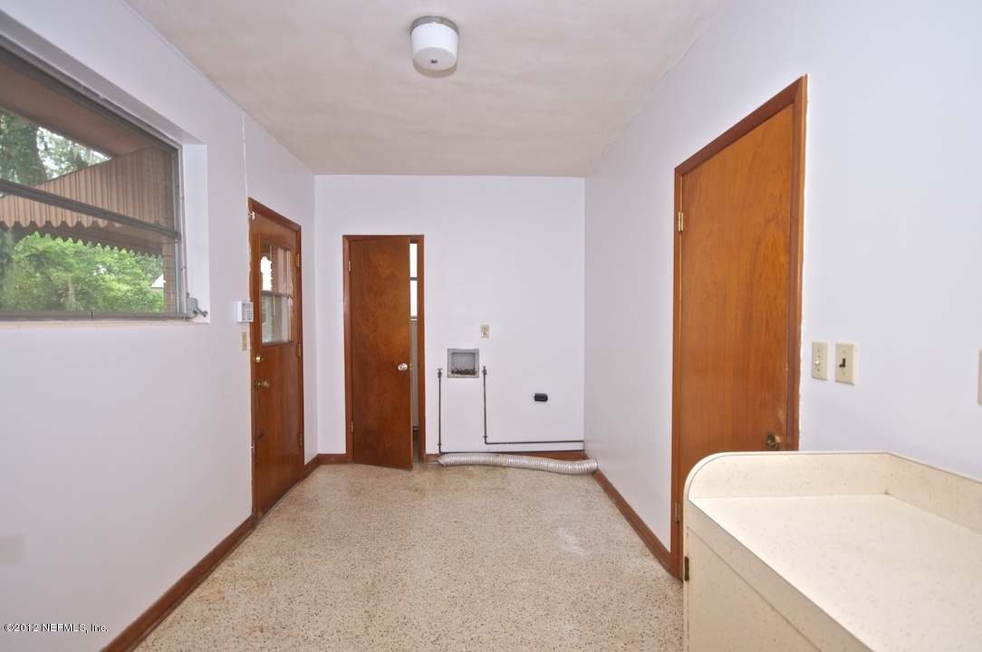 4149 Rogero Road Jacksonville, FL 32277 - Photo 25 of 27 a view of a bedroom with a bed and wooden floor