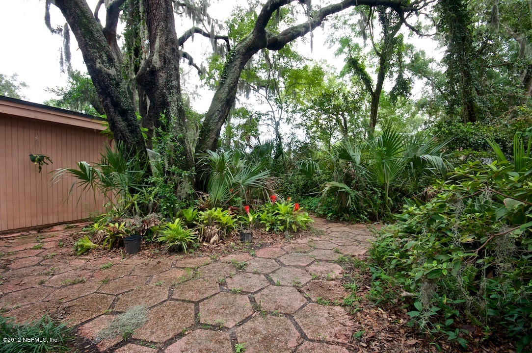 4149 Rogero Road Jacksonville, FL 32277 - Photo 4 of 27 a backyard of a house with lots of green space