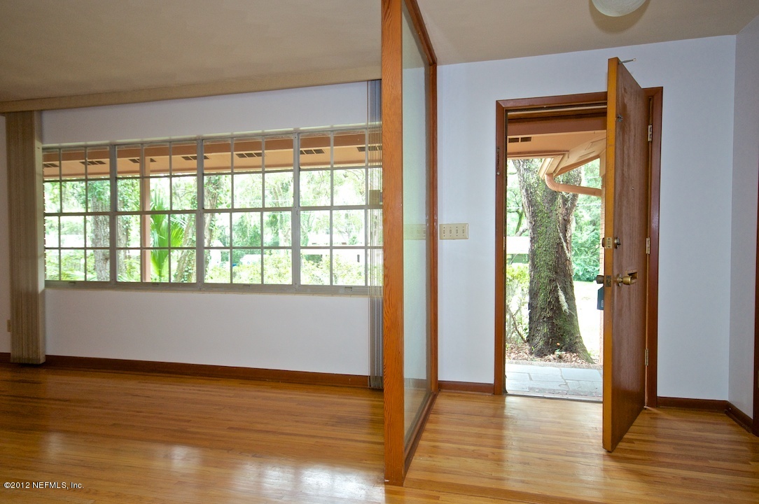 4149 Rogero Road Jacksonville, FL 32277 - Photo 6 of 27 a view of an empty room with wooden floor and a window
