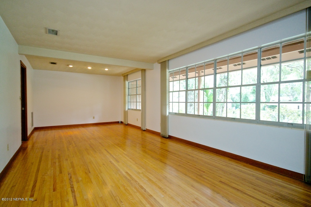 4149 Rogero Road Jacksonville, FL 32277 - Photo 7 of 27 a view of an empty room with wooden floor and a window