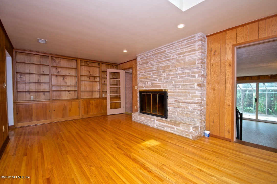 4149 Rogero Road Jacksonville, FL 32277 - Photo 10 of 27 a view of empty room with wooden floor and fireplace