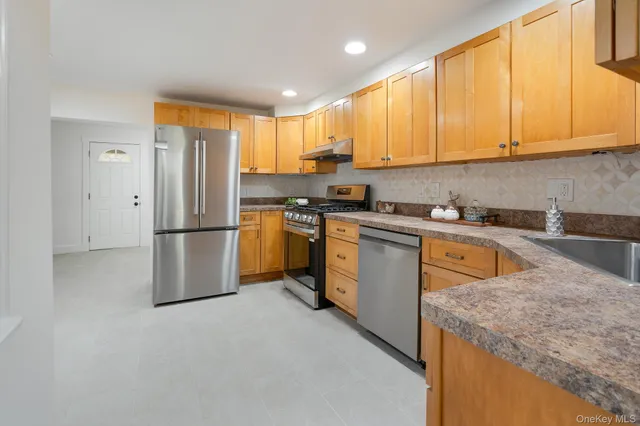 a kitchen with stainless steel appliances granite countertop a refrigerator sink and cabinets