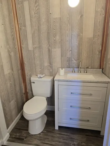 a bathroom with a granite countertop toilet and a sink
