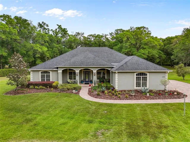 a front view of a house with a garden and yard