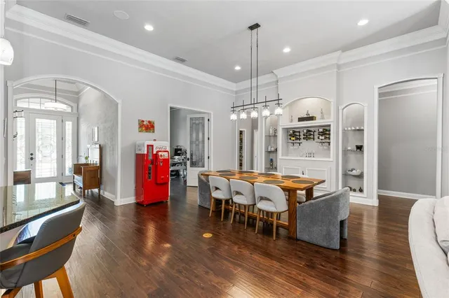 a living room with furniture kitchen view and a chandelier