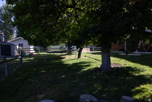 827 South 600 East Logan, UT 84321 - Photo 28 of 30 Expansive backyard featuring mature trees, a manicured lawn, and a perimeter fence
