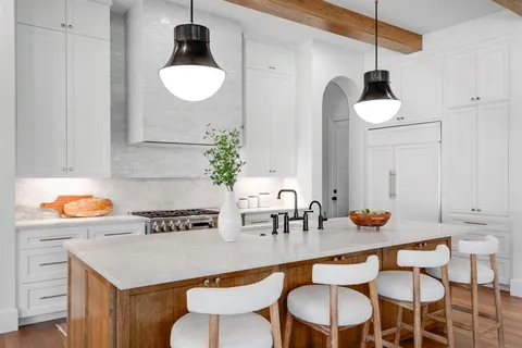a kitchen with a table chairs sink and cabinets