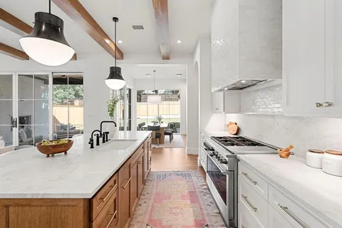a kitchen with stainless steel appliances a sink a stove and a wooden floor
