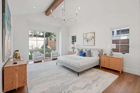 a bedroom with a bed and a dresser next to a window