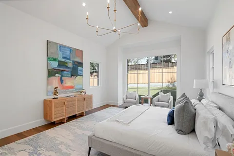 a bedroom with a bed wooden floor and window