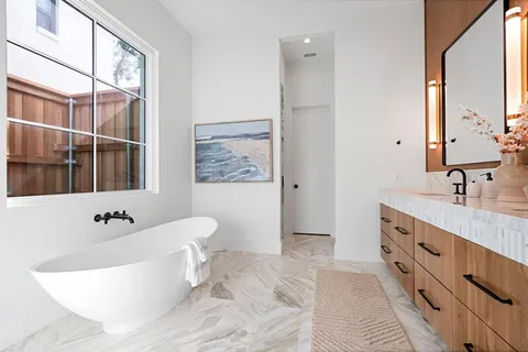 a spacious bathroom with a tub sink and mirror