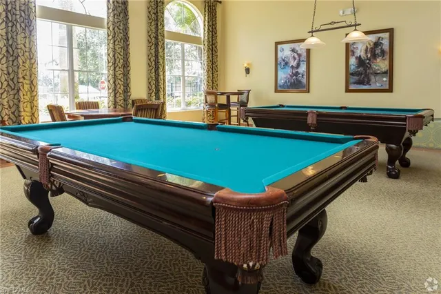 a room with pool table and windows
