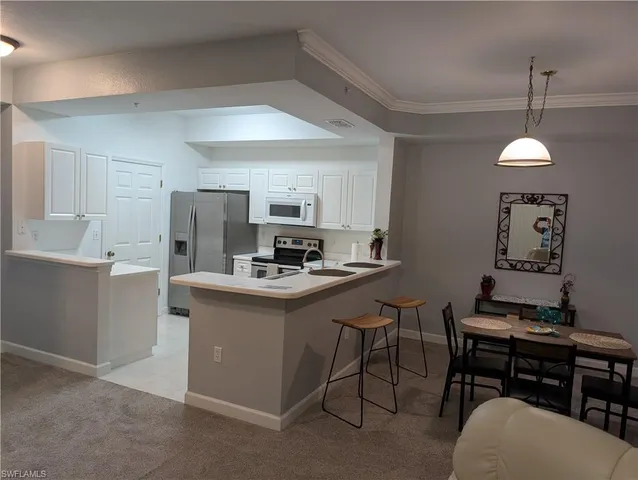 a kitchen with kitchen island a stove a table and chairs in it