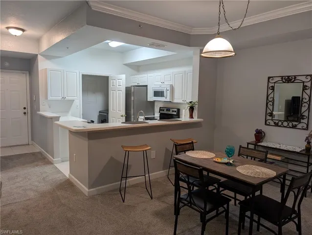 a kitchen with a dining table chairs and white cabinets
